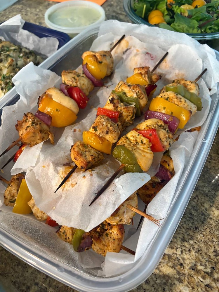 Close-up of chicken and vegetable kebabs in a container.