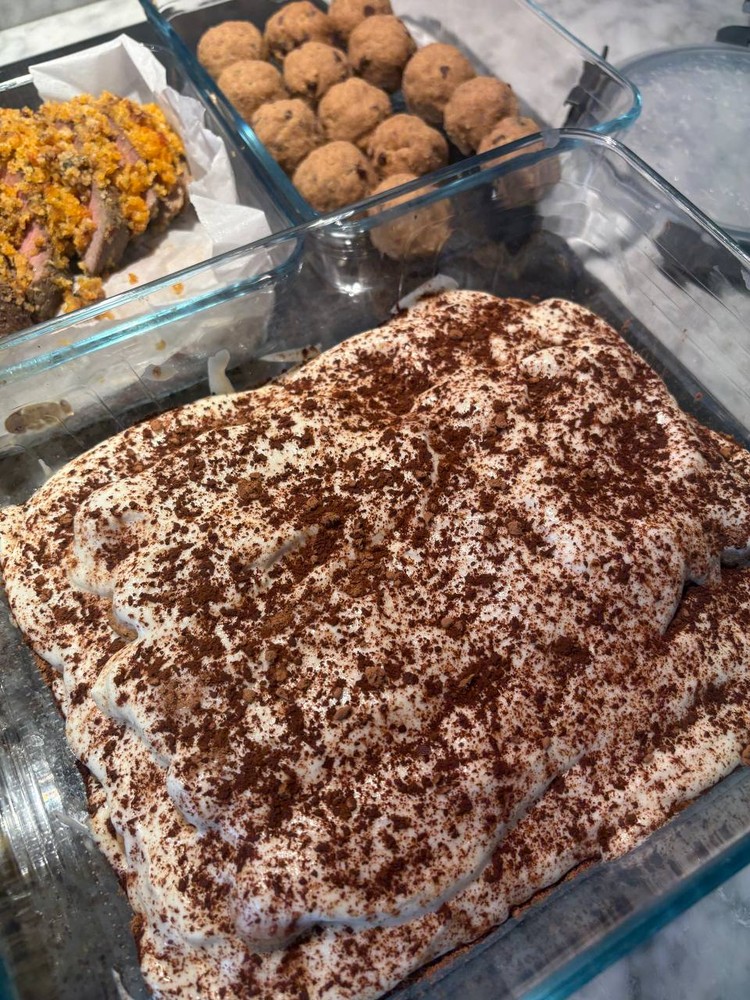 Tiramisu dessert with cocoa powder dusting next to protein balls.