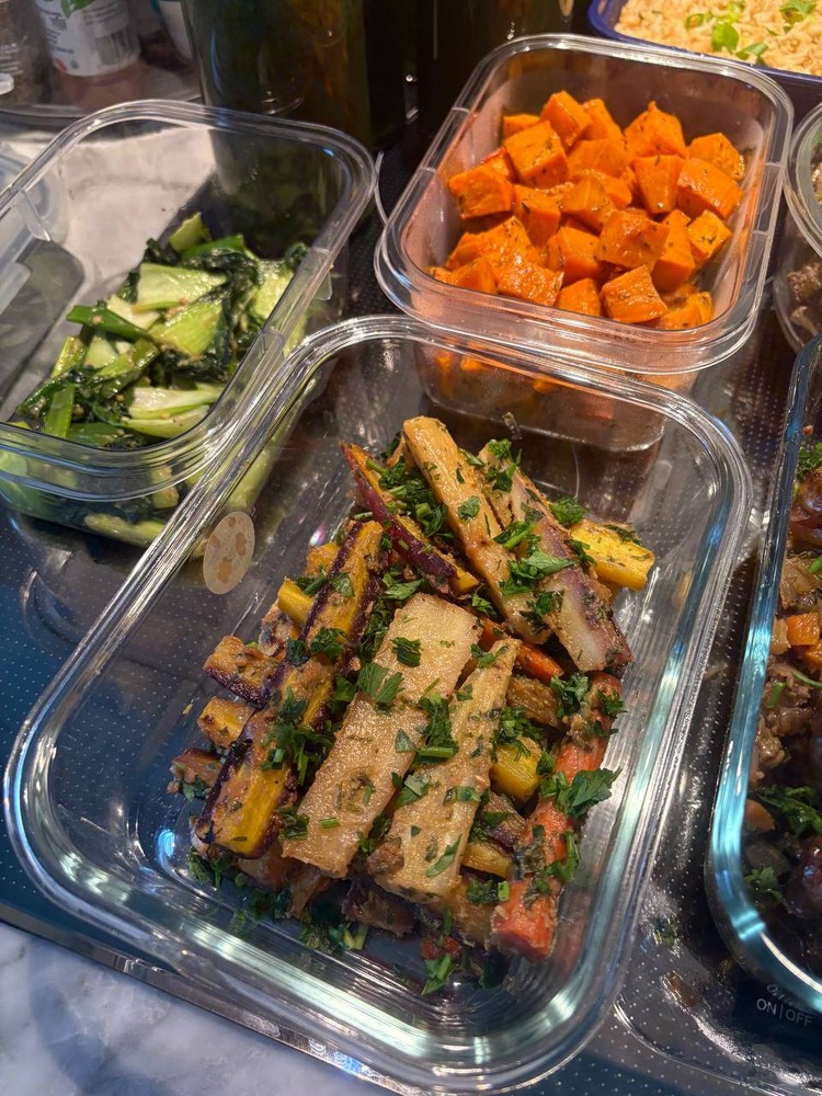 Roasted root vegetables and sautéed bok choy in glass containers.