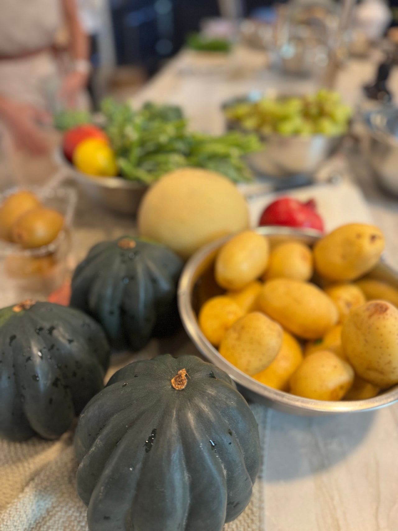 Acorn squash, lemons, melon and other fresh produce arranged on the kitchen counter.