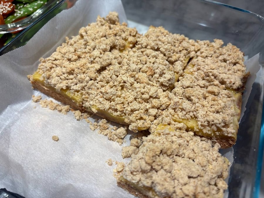 Lemon crumble bars in a glass container.