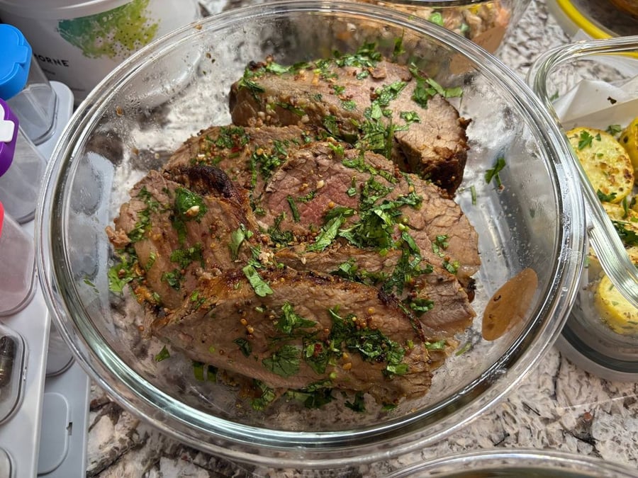 Sliced beef with fresh herbs in a glass container