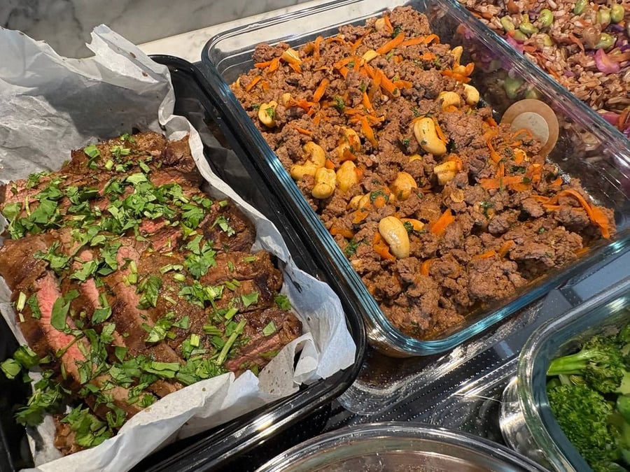Close-up of sliced steak with herbs and ground meat with cashews.