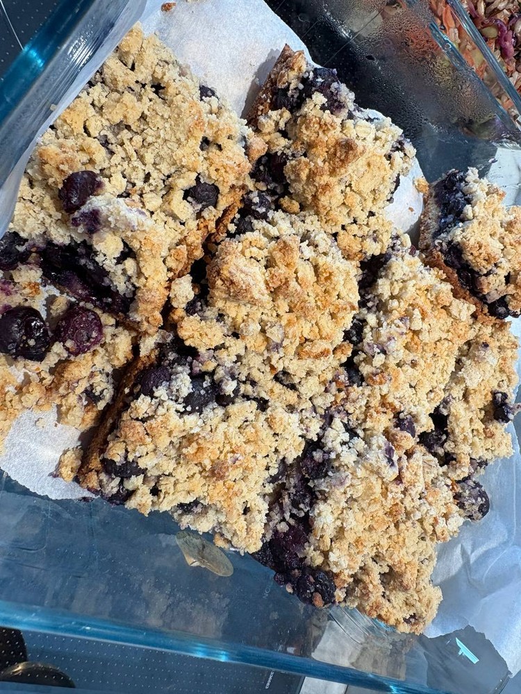 Close-up of blueberry crumble bars in a glass dish.